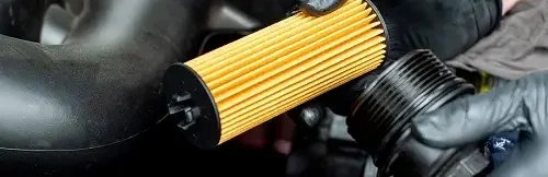 Recommended Pre-Winter Maintenance for European Cars | Heights Swedish Solutions in Cleveland Heights, OH. Closeup image of a mechanic’s hand holding a car oil filter that’s for replacement.