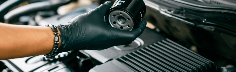 Types of Car Filters and Why You Need to Change Them | Heights Swedish Solutions at Cleveland Heights, OH. Image of an auto technician in the act of replacing an oil filter.