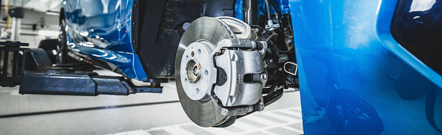 Exposed brake system of a blue BMW car. Concept image of “Do European Car Brakes Need Extra Attention?” | Heights Swedish Solutions in Cleveland Heights, OH.