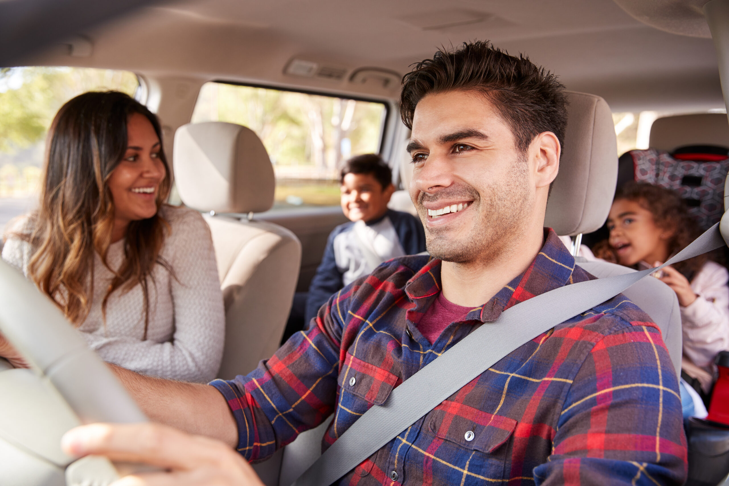 European Car Pre-Holiday Checklist | Heights Swedish Solutions. Image of mother turning around smiling at children in back seat of the car while dad is driving.