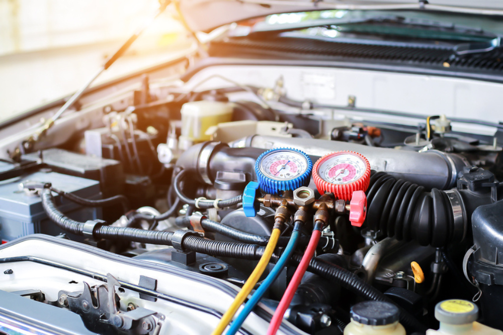 A/C Recharge Services in Cleveland Heights, OH by Heights Swedish Solutions: Close-up view of car air conditioner service gauges connected to a vehicle, emphasizing the importance of proper A/C maintenance and recharging for optimal cooling performance.